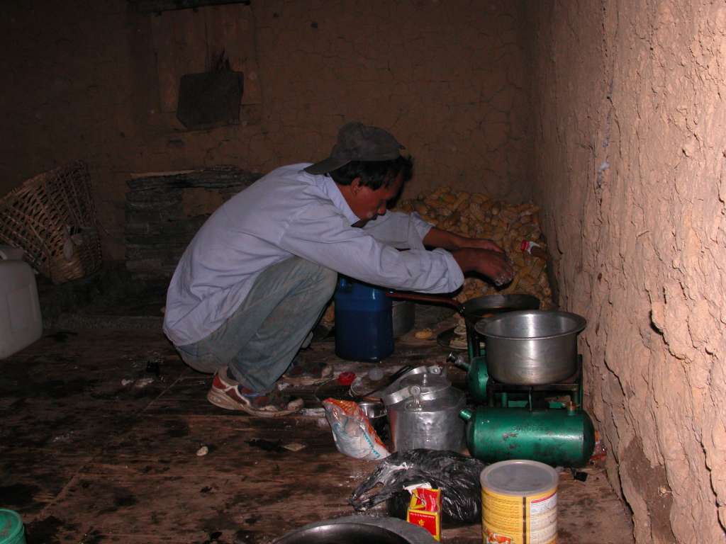 Manaslu 05 01 Cooking Breakfast We camped in a farmers field in Ekle Bhatti (1600m) and were up before sunrise the next morning with Schandra cooking breakfast.